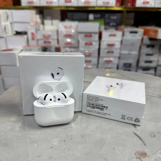 White wireless earbuds with charging case on a table in a store setting