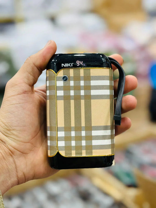 Hand holding a phone with a plaid case labeled 'Niki' against a blurred background